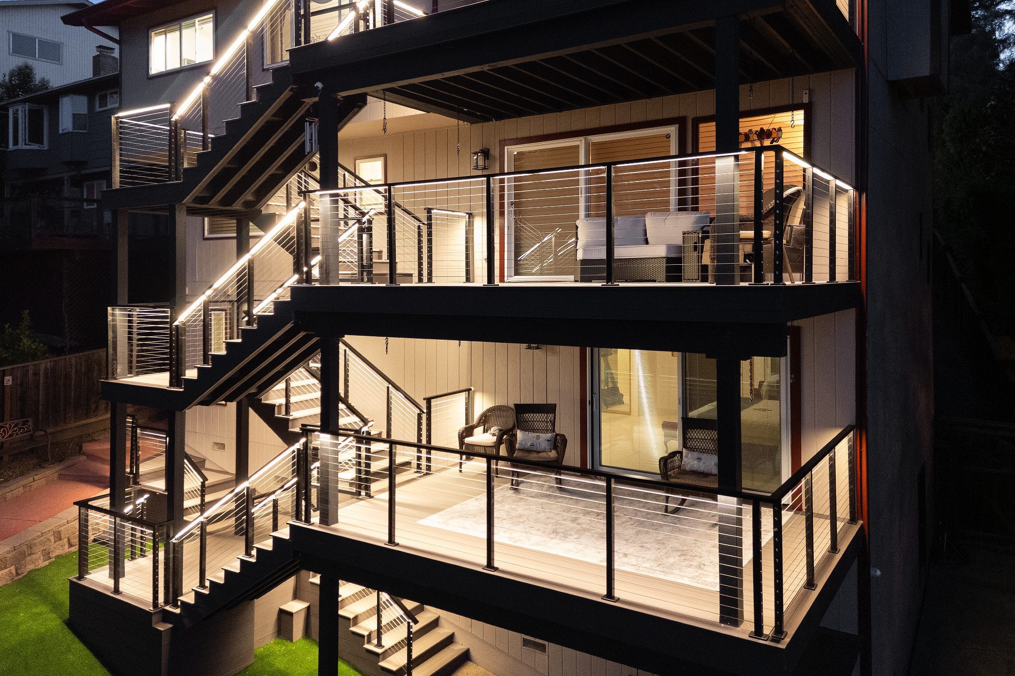 Multi-level deck with cable railing and LED lighting at night in Belmont, CA