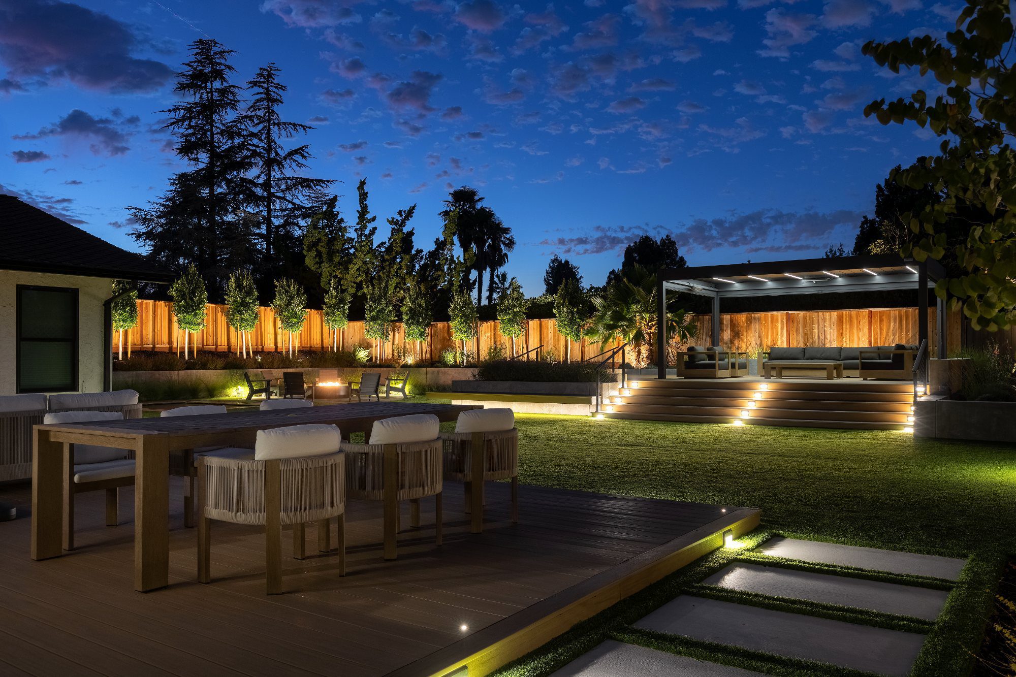 Outdoor dining on a composite deck with cable railing at dusk in Saratoga, CA