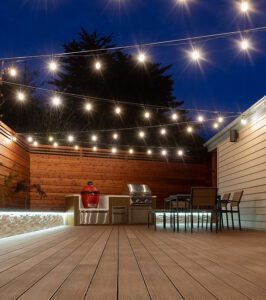 Backyard deck at night with string lights and seating