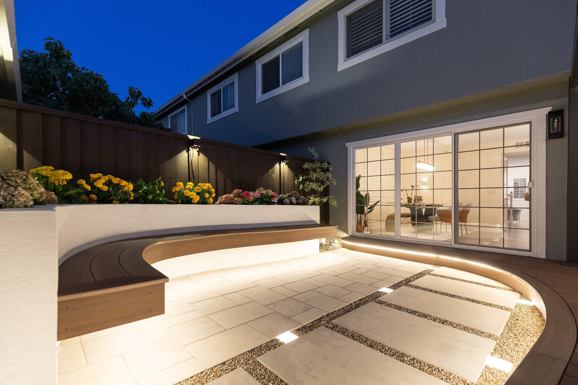 Night view of a lit deck, built-in bench and pavers in Foster City, CA